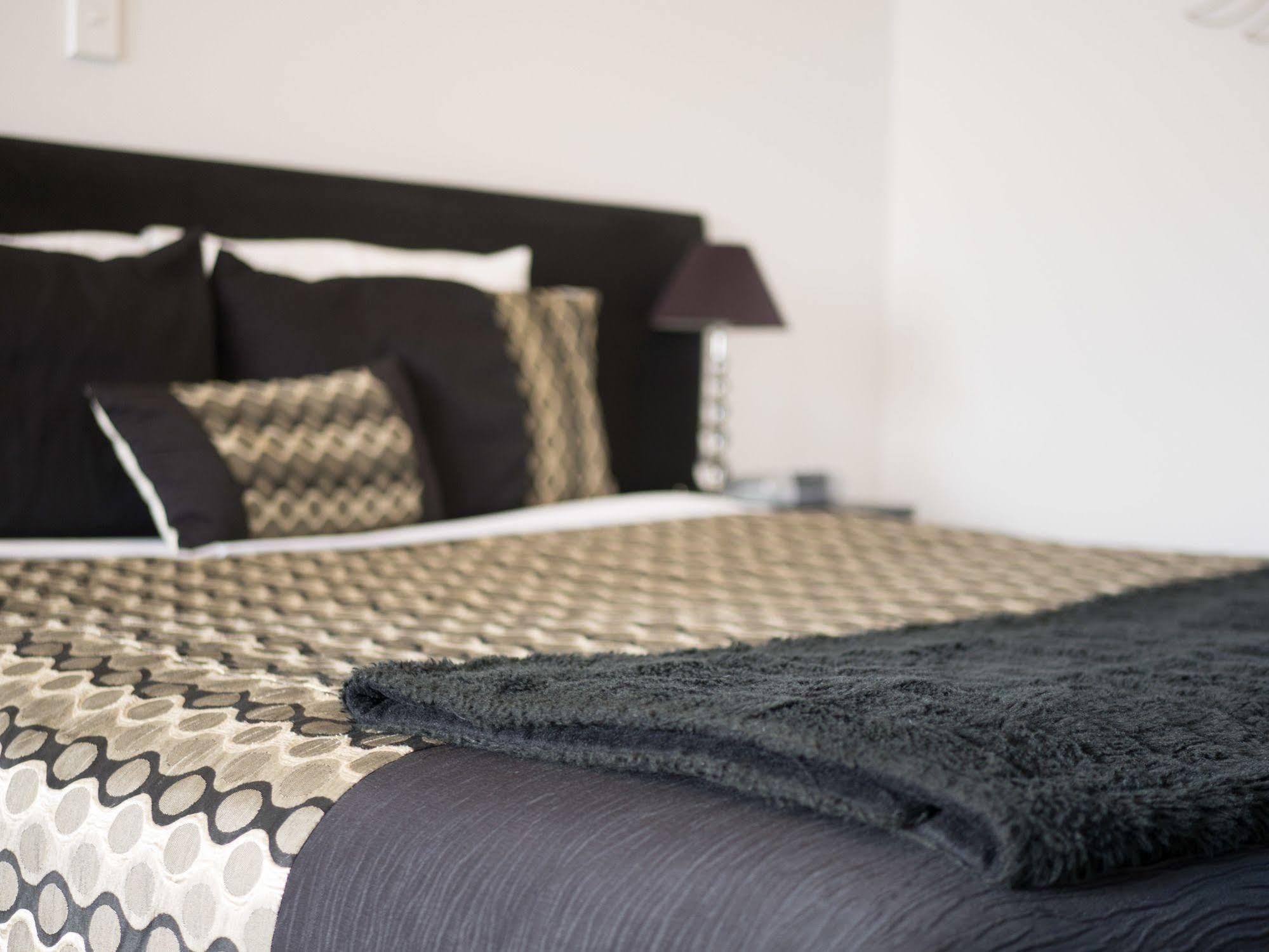 Bellano Motel Suites Christchurch Exterior foto A bed with a throw